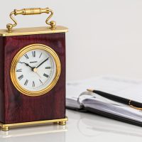 编辑老周伏案核对六级报名时间公告原文，桌面上摊着打印稿与标记笔，午后阳光透过百叶窗落在纸面上，气氛安静专注